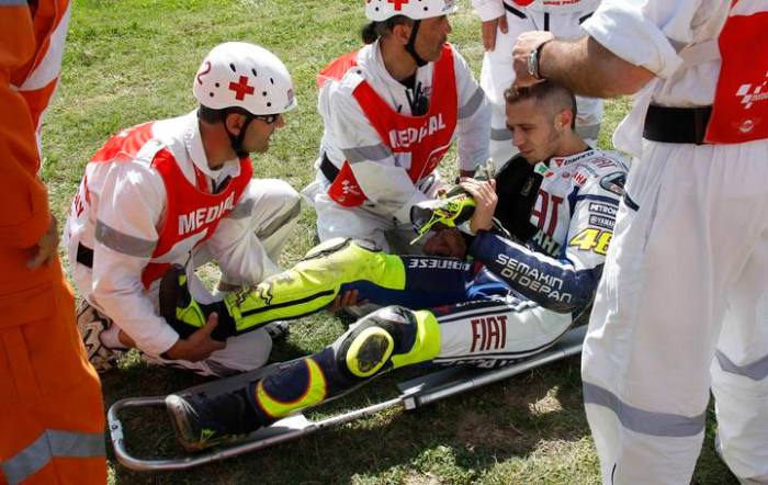 Yamaha MotoGP rider Rossi of Italy has his right leg checked by a doctor following a crash during the second free practice of the Italian motorcycling Grand Prix at the Mugello circuit